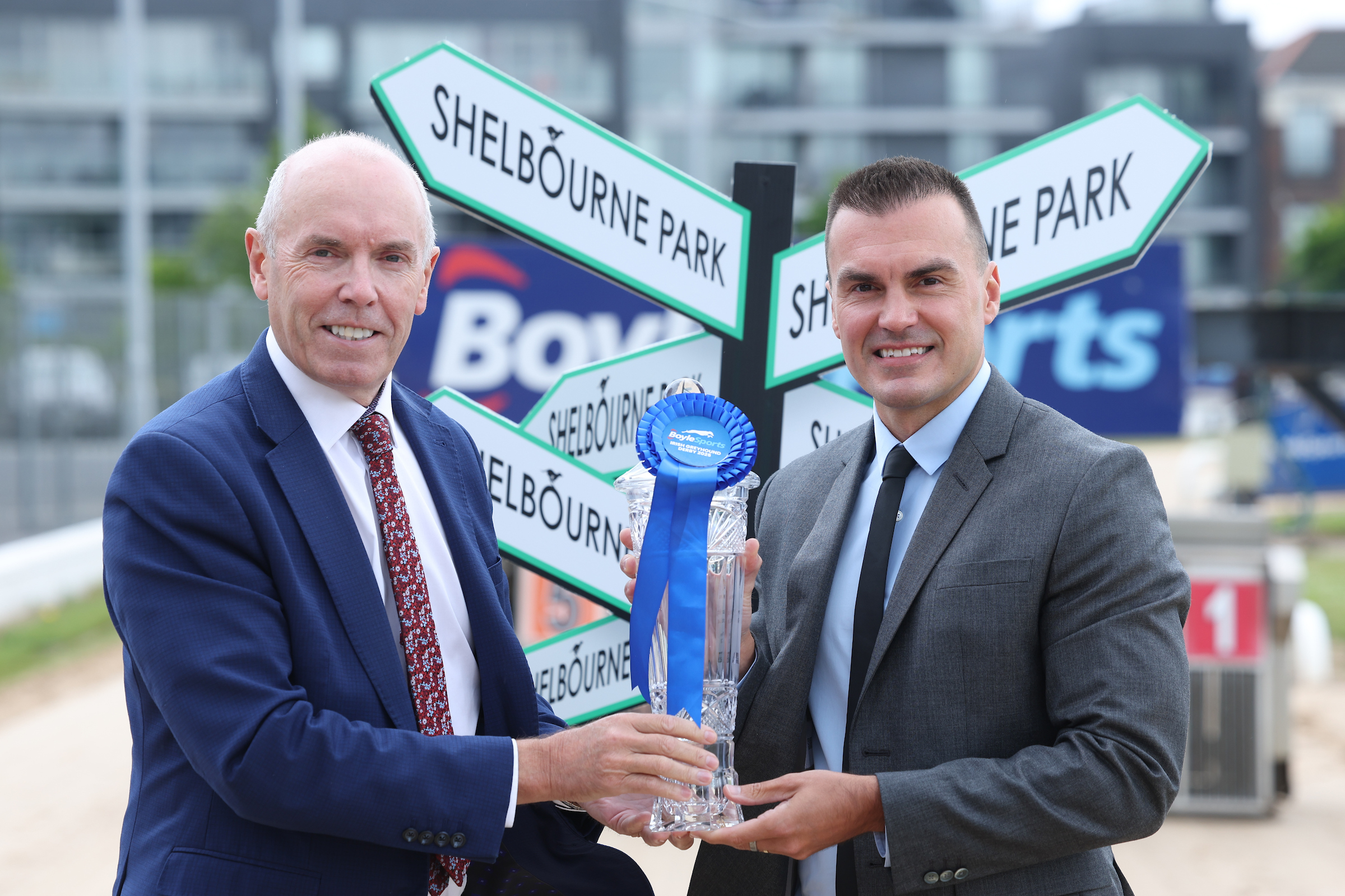 Image shows Tim Lucey CEO of Greyhound Racing Ireland and Vlad Kaltenieks CEO of BoyleSports on the track at Shelbourne Park holding the 2025 BoyleSports Irish Greyhound Derby winner's trophy