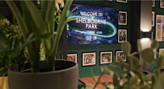 The Food Hall offers a spacious area for customers who are enjoying racing in Shelbourne Park to get food and sit down and eat in a dedicateed dining space before returning to the bar our outdoor viewing areas to enjoy racing Image shows a screen in the new Food Hall welcoming you to Shelbourne Park with photographs surrounding it and lush greenery